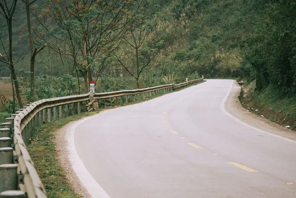 A quiet paved road winding through green hills
