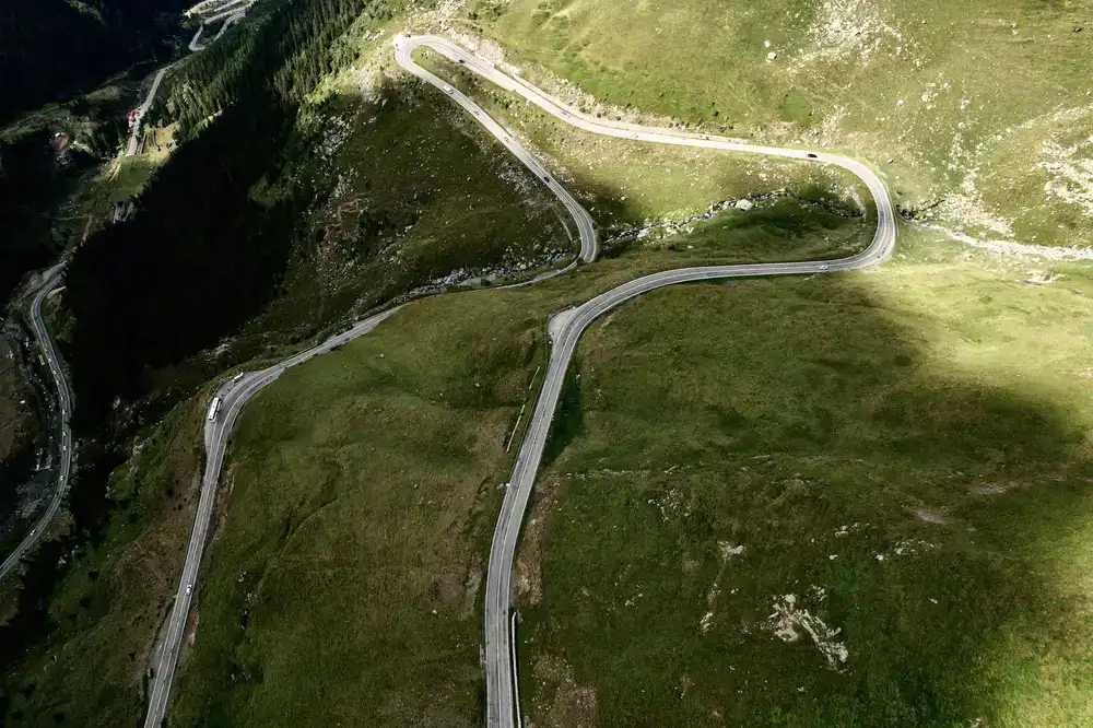 Advanced cyclist navigating a winding hillside route with sweeping views
