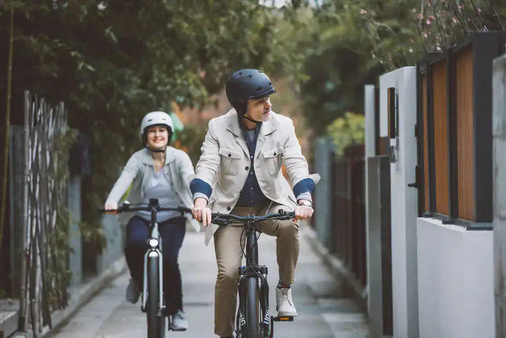 Couple riding electric bicycles effortlessly along a flat scenic lane