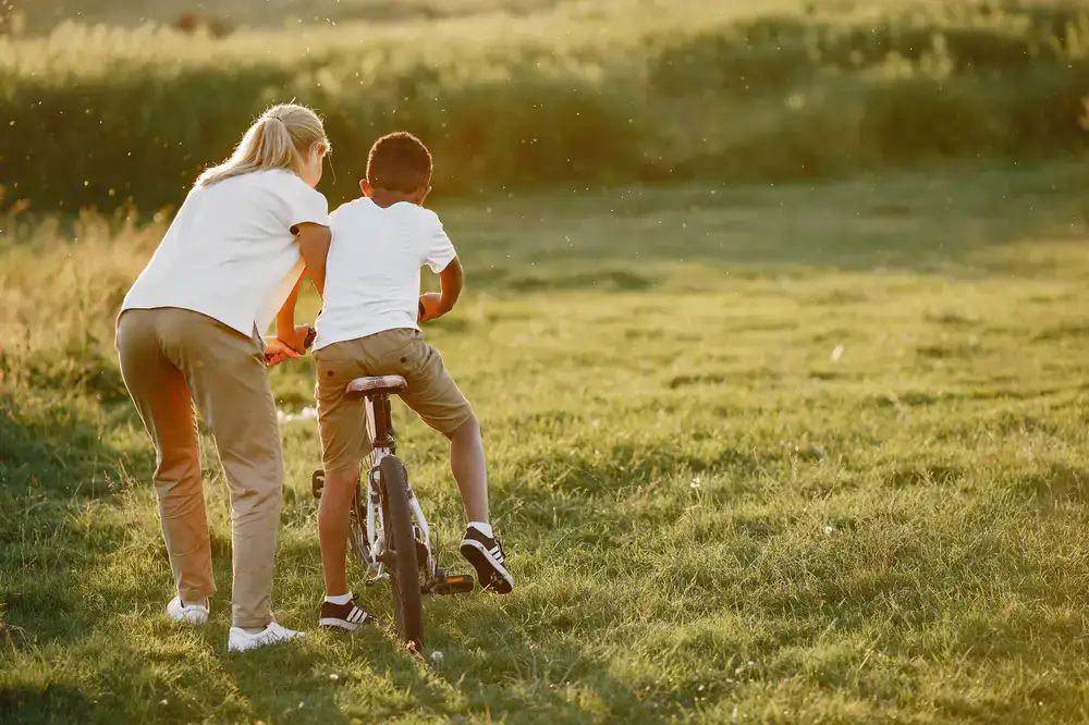 Family enjoying a casual bicycle ride past sunny fields and farmhouses